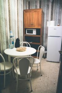 cocina con mesa, sillas y nevera en Hostal La Toba, en Cañete