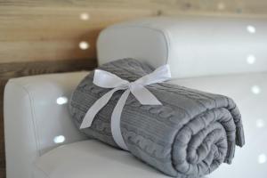 a blanket on a white chair with a bow at Chalet n. 5 in Carano