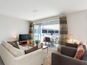 ein Wohnzimmer mit 2 Sofas und einem TV in der Unterkunft High Tides Lookout - Paihia Holiday Home in Paihia