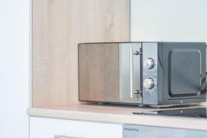 a microwave oven sitting on top of a counter at Il Mare appart hotel 1,2,4 in Luxembourg