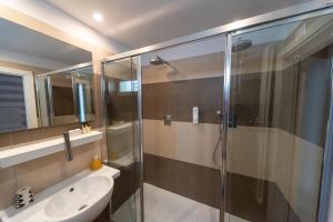 uma casa de banho com uma cabina de duche em vidro e um lavatório. em Hotel Fedora Riccione em Riccione