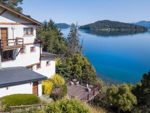 een huis met uitzicht op een meer bij Hosteria Santa Rita in Bariloche