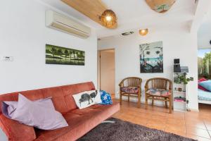 a living room with a couch and two chairs at Surfinn Eco Cottage - Papatowai Cottage in Papatowai