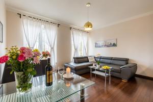 a living room with a couch and a table with flowers at Rezidence Moser Apartments in Karlovy Vary