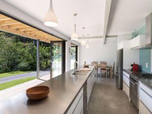 an open kitchen with a large counter and a dining room at Paihia Centre Peace - Central Paihia Holiday Home in Paihia