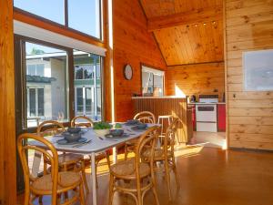 a dining room with a table and chairs in a kitchen at Estuary Escape - Pauanui Holiday Home in Pauanui