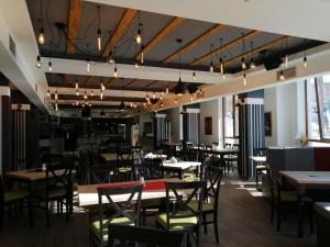 a dining room with tables and chairs and chandeliers at AMI apartman Kopaonik in Kopaonik