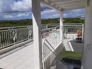 a balcony with a white railing and a view at Flamboyant in Sainte-Anne
