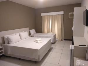 Kama o mga kama sa kuwarto sa Hotel Guarujá Inn Tropical