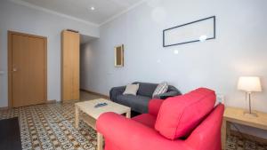 バルセロナにあるApartamento Entençaのリビングルーム(赤い椅子、ソファ付)