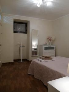 biały pokój z łóżkiem i lustrem w obiekcie Apartamento EntreCaminos w mieście Setenil