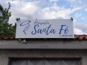 a sign on a building with a sign for a restaurant at Pousada Santa Fé in Aparecida