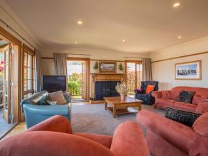 a living room with red couches and a tv at McAlister House - Queenstown Holiday Home in Queenstown