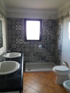 a bathroom with two sinks and a toilet and a window at villa Fiametta in Pula