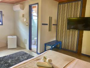 a room with a bed and a sliding glass door at Vila Pequeá Ilhabela in Ilhabela