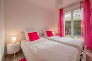 - une chambre avec 2 lits dotés d'oreillers rouges et d'une fenêtre dans l'établissement EDEN PARK LUXE DISNEY, à Montévrain