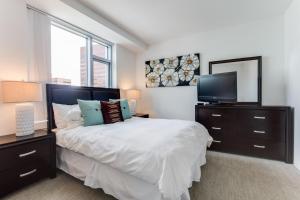 a bedroom with a bed with a television and a mirror at Global Luxury Suites at Kendall East in Cambridge