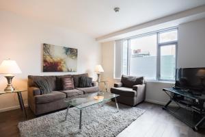 ケンブリッジにあるGlobal Luxury Suites at Kendall Eastのソファとテレビのあるリビングルーム