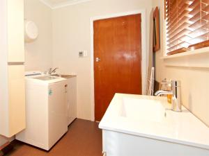 a kitchen with a sink and a wooden door at Raetihi Cottage- Raetihi Holiday Home in Raetihi +18 photos