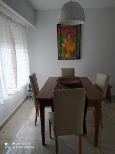 坦迪爾的住宿－Depto El Puma，餐桌、椅子和墙上的绘画