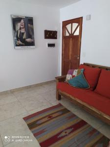 坦迪爾的住宿－Depto El Puma，客厅配有红色沙发和门