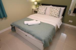 a bedroom with a bed with two towels on it at The Lavenders in Bracknell