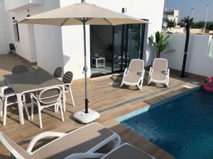 a patio with a table and chairs and an umbrella at Casa Ribalta in San Pedro del Pinatar