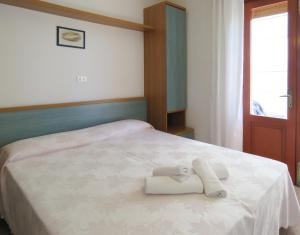 a bedroom with a bed with two towels on it at Hotel Saturno in Lido di Jesolo +24 photos