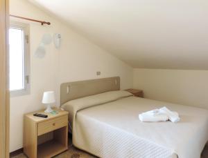 Un pat sau paturi într-o cameră la Hotel Saturno
