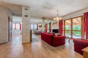 uma sala de estar com sofás vermelhos e uma sala de jantar em Domki nad Jeziorem em Rajgród