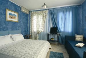 蒙泰羅索阿爾馬雷的住宿－布蘭科農莊酒店，卧室拥有蓝色的墙壁,配有一张床和一张沙发