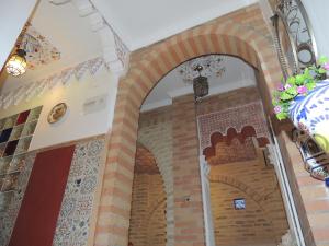 un arco en un edificio con azulejos en las paredes en Casa Marhaba - Welcome, en Sevilla