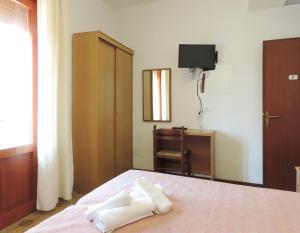 a bedroom with a bed with two towels on it at Hotel Saturno in Lido di Jesolo