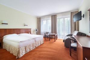 ミコワイキにあるPokoje Fregataのベッドとデスクが備わるホテルルームです。