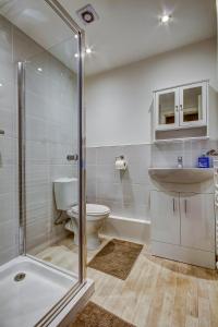 uma casa de banho com um chuveiro, um WC e um lavatório. em Garden Gate Upper Apartment em Prestwick