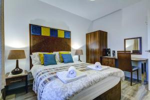 a bedroom with a large bed with towels on it at Garden Gate Upper Apartment in Prestwick