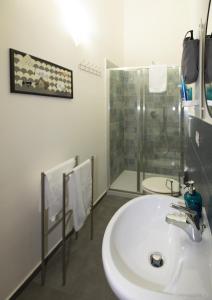 a bathroom with a white sink and a shower at Sichelgaita Apartment in Salerno
