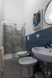 a bathroom with a toilet and a sink and a shower at Sichelgaita Apartment in Salerno