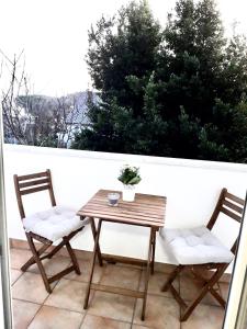 drewniany stół i 2 krzesła na balkonie w obiekcie La Madre w mieście Rijeka