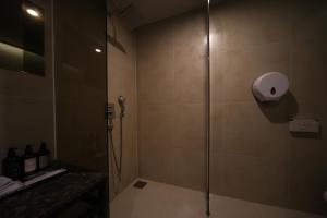 a shower with a glass door in a bathroom at Beomil Brown Dot Hotel in Busan