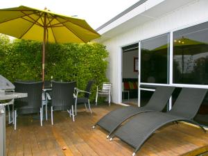 patio con tavolo, sedie e ombrellone di Taupo Haven - Taupo Holiday Unit a Taupo