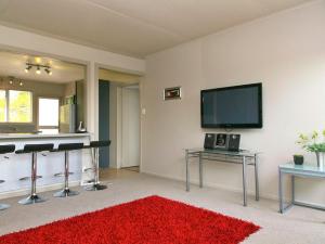 un soggiorno con tappeto rosso e TV a schermo piatto di Taupo Haven - Taupo Holiday Unit a Taupo