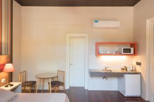 a room with a bed and a kitchen with a table at La Casona Apart Boutique in Marcos Juárez