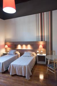 a hotel room with two beds and a table at La Casona Apart Boutique in Marcos Juárez