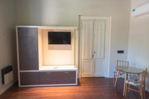 a living room with a flat screen tv and a table at La Casona Apart Boutique in Marcos Juárez
