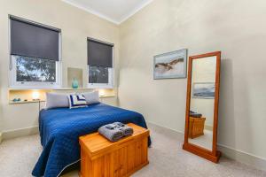 a bedroom with a blue bed and a mirror at The Jazz B&B in Naracoorte