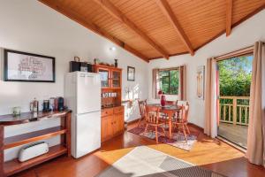 a kitchen with a white refrigerator and a table at Treetop Hideaway - Taupo Holiday Home in Taupo