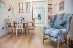 a living room with a chair and a table at The Gardener's Cottage in Dunblane