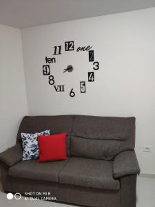 a large clock on a wall above a couch at SATI 2 A in Santa Cruz de la Palma