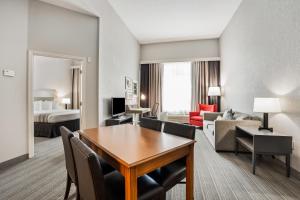 a hotel room with a table and a living room at Country Inn & Suites by Radisson, Port Canaveral, FL in Cape Canaveral